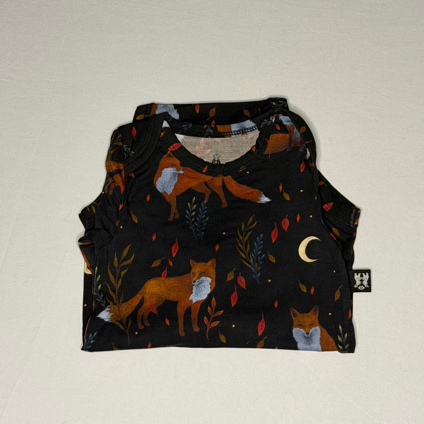 Baby romper with fox pattern on a beige background