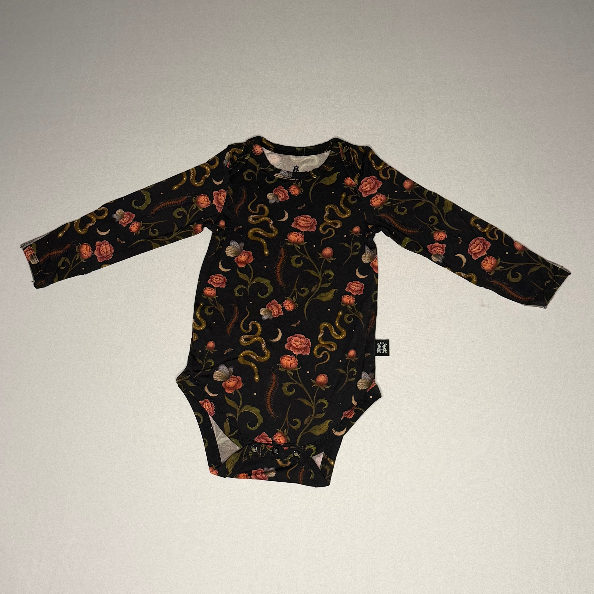 Black baby onesie with floral pattern on a white background