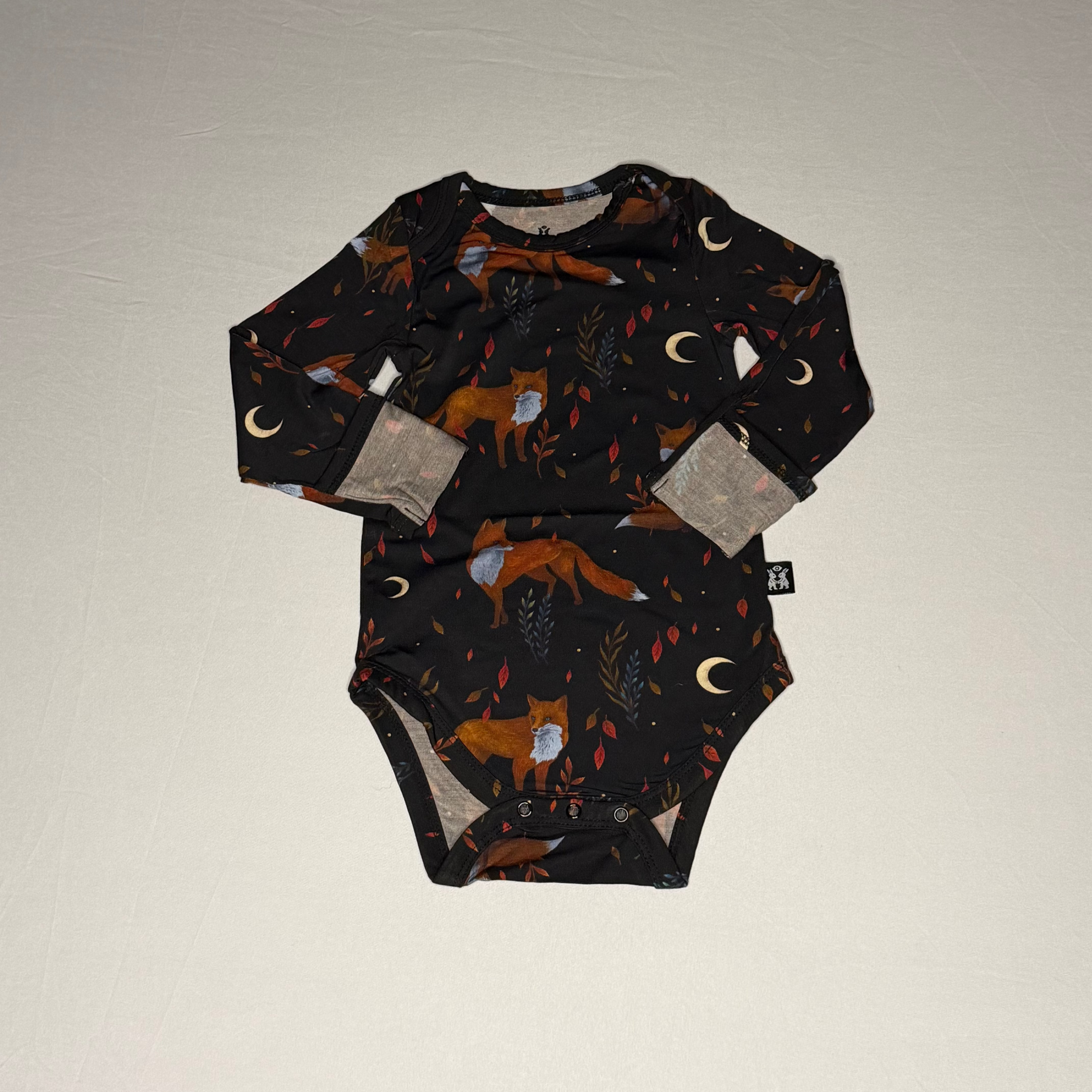 Baby onesie with fox pattern on a plain background