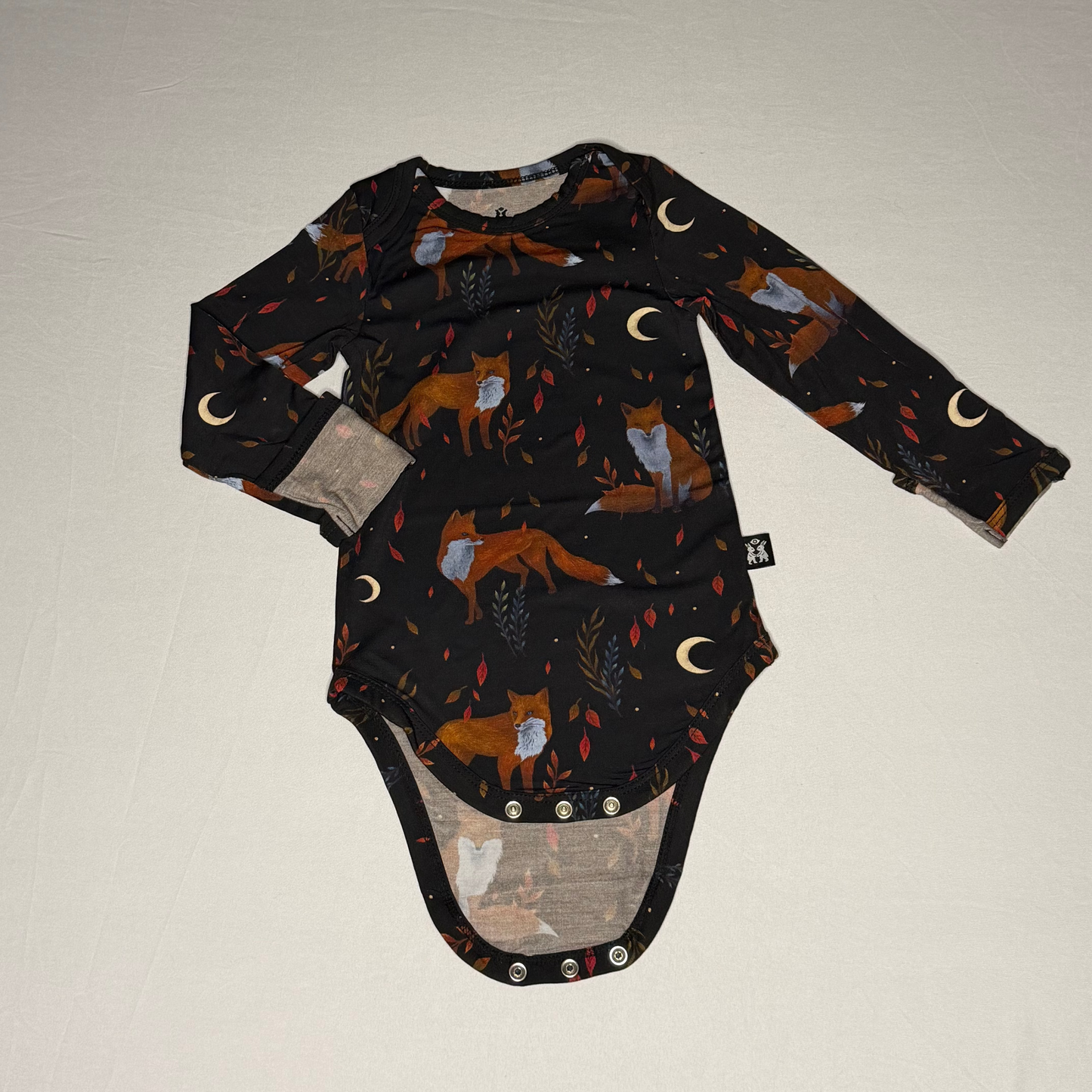 Baby onesie with fox pattern on a plain background