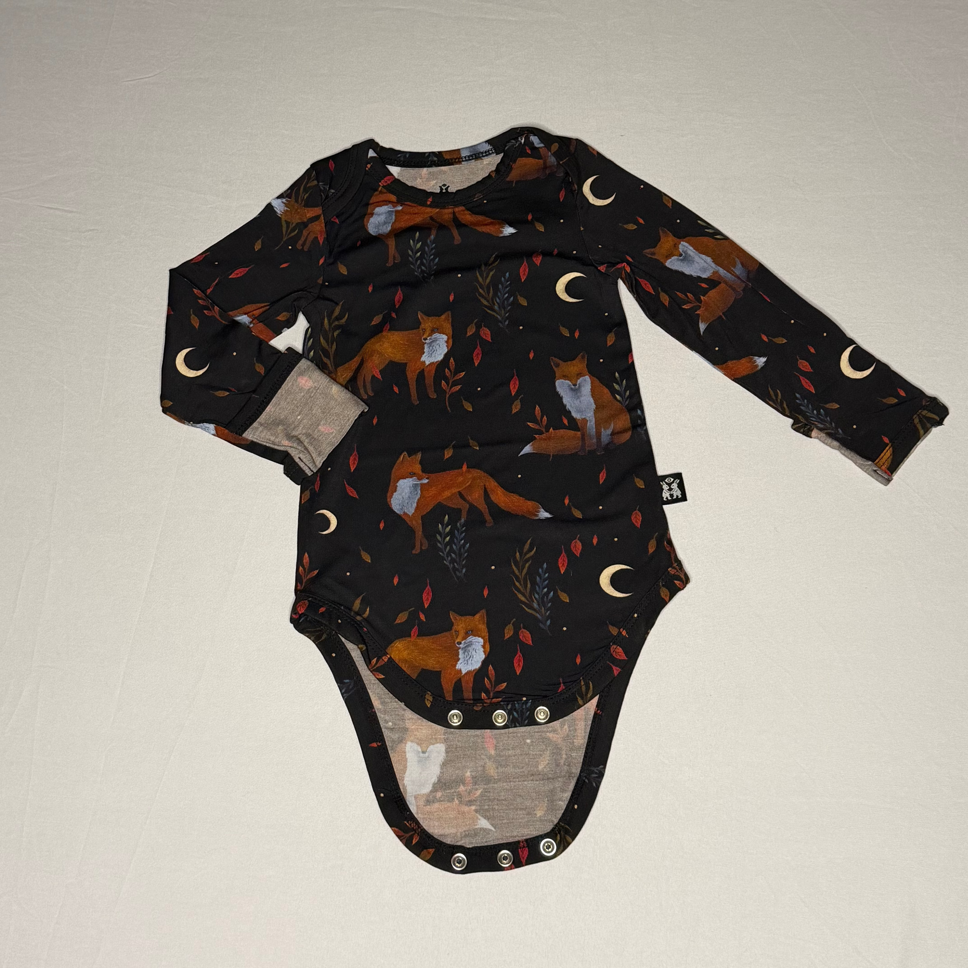 Baby onesie with fox pattern on a plain background