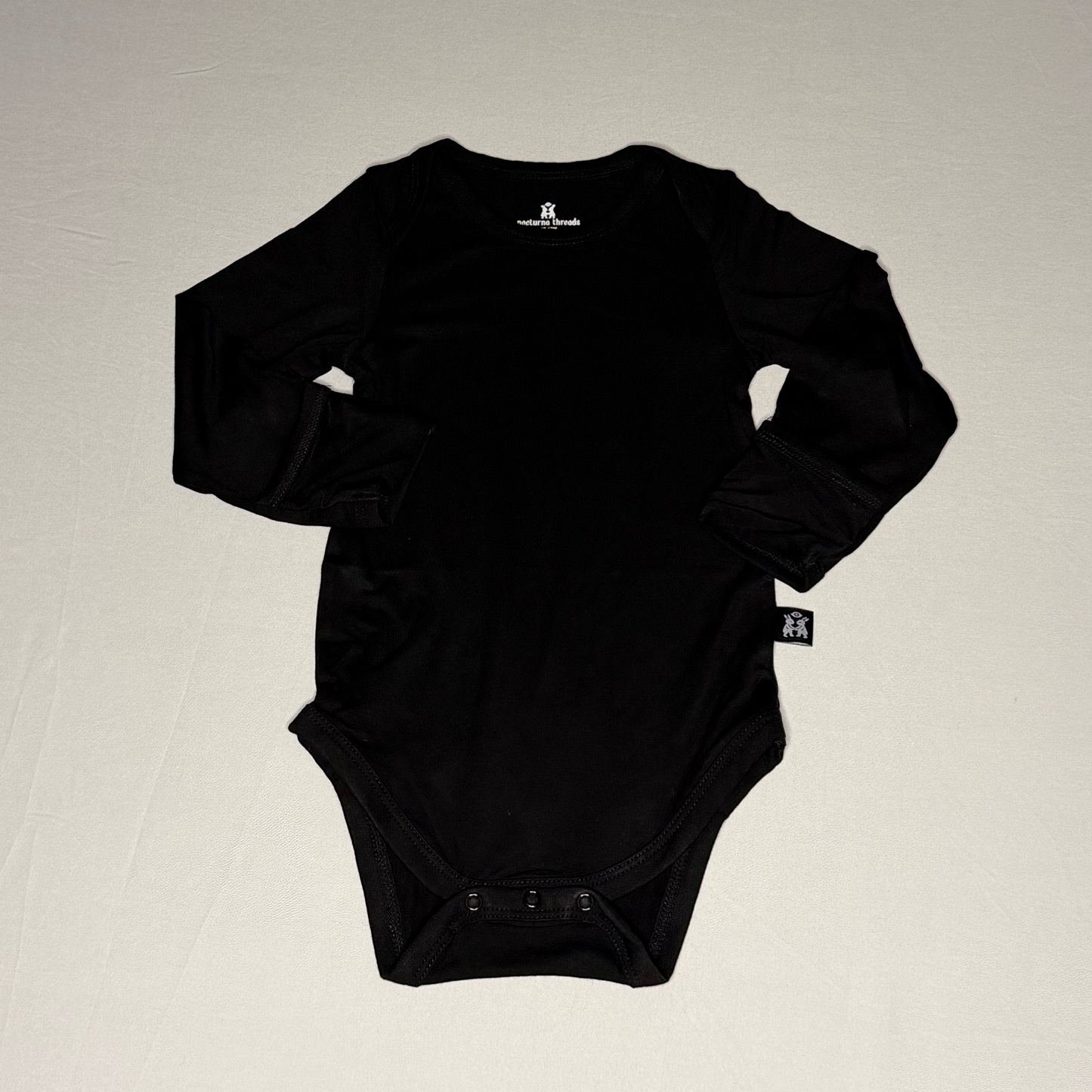 Black baby onesie on a light gray background