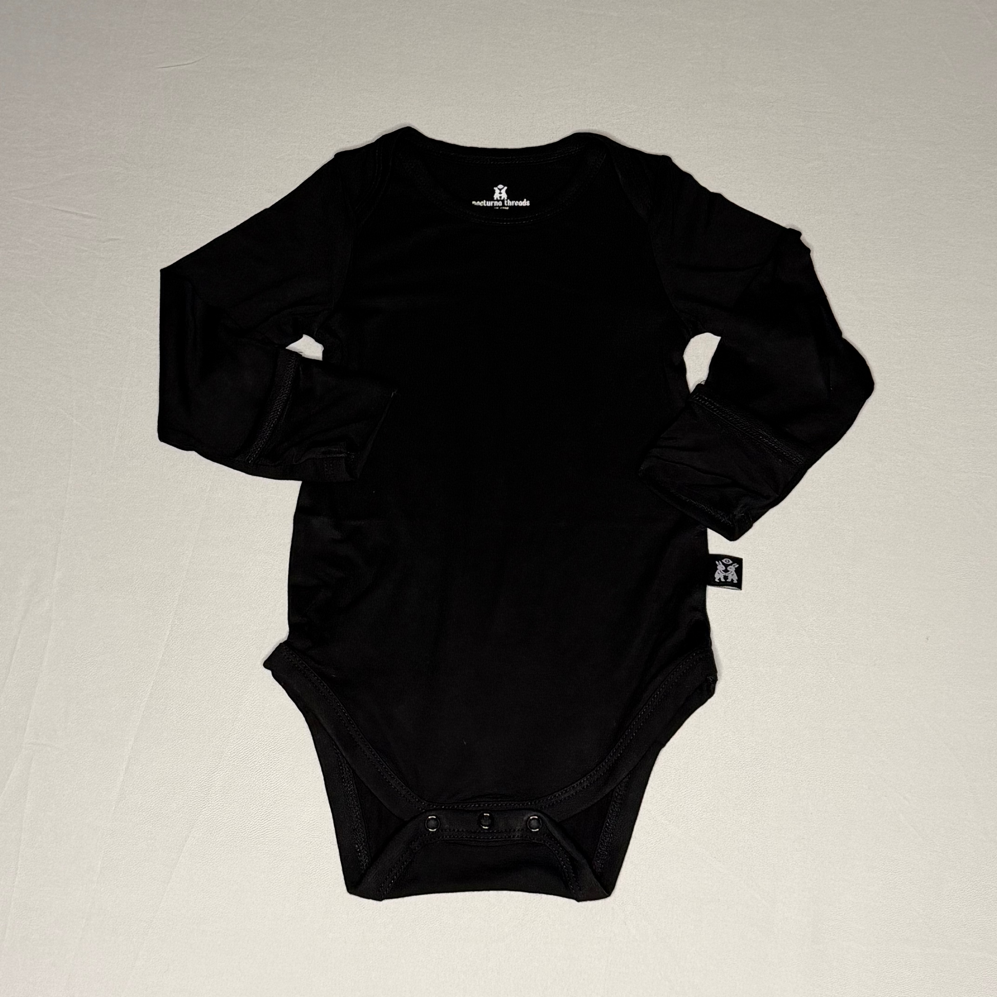 Black baby onesie on a light gray background