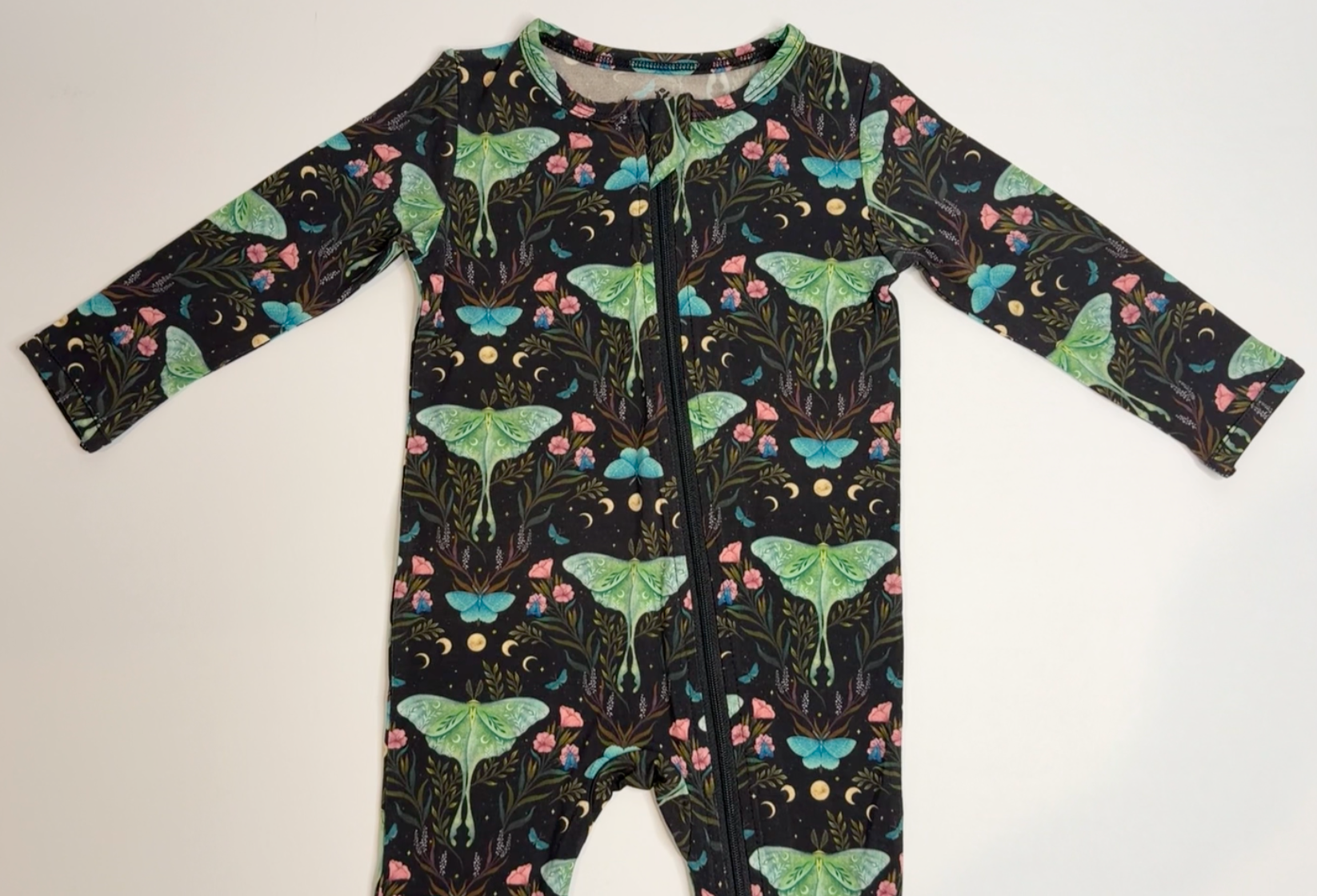 Children's onesie with moth and floral pattern on a white background